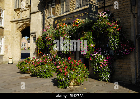 Eine Blütenpracht vor dem National Trust-Geschenk-Shop von mittellosen Veranda im Marktplatz, Wells, Somerset, England Stockfoto