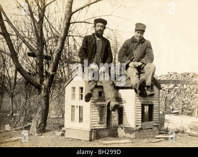 Zwei Arbeiter sitzt auf Miniaturhaus Stockfoto