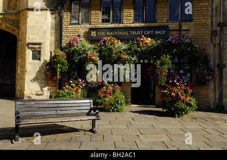 Eine Blütenpracht vor dem National Trust-Geschenk-Shop von mittellosen Veranda im Marktplatz, Wells, Somerset, England Stockfoto