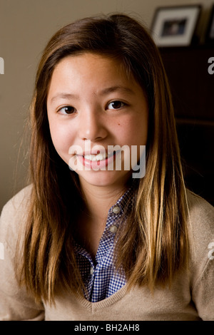 Fröhliches 11-jährige Koreanisch/weiß Mädchen lächelnd in die Kamera, Porträt. Stockfoto