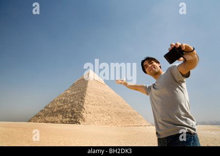 Mann, der ein Bild von sich mit Pyramide im Hintergrund Stockfoto