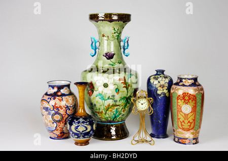 Eine Gruppe von antiken Vasen, darunter eine riesige französische Vase von Theodore Deck, zwei japanische Vasen, eine Uhr und zwei Jugendstil-Vasen. Stockfoto