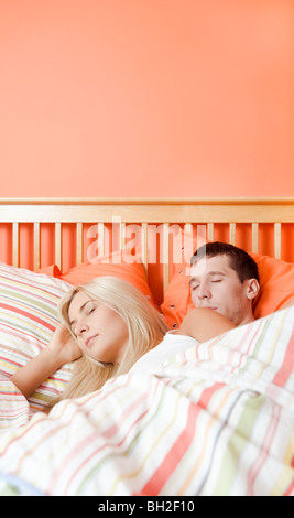 Junges Paar Schlaf eng zusammen unter einer gestreiften Bettdecke. Vertikale erschossen. Stockfoto