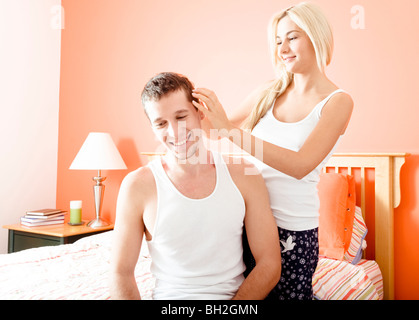 Frau mit Rüschen Mannes Haare, wie sie in ihrem Schlafzimmer zu entspannen. Querformat. Stockfoto