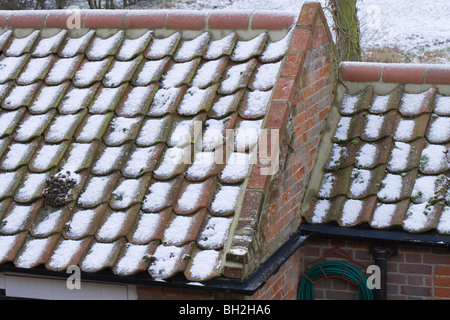 Schnee und Hagel Steinen auf Flachdachziegel Dach von einem Nebengebäude. Stockfoto