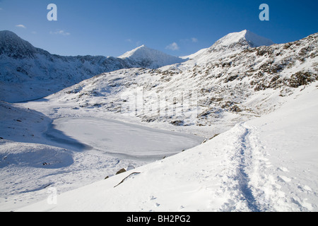 Gwynedd North Wales UK Januar Blick auf gefrorenen Llyn Teyrn in Richtung Schnee bedeckt Snowdon Horseshoe und Crib Goch von Bergleuten Spur Stockfoto