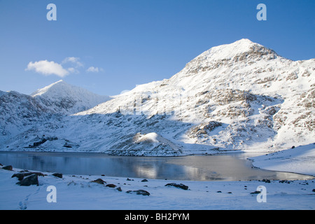 Gwynedd North Wales UK Blick über gefrorene Llyn Llydaw in Richtung Schnee bedeckt Snowdon Horseshoe und Crib Goch von Bergleuten Spur Stockfoto