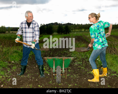 Mann und Frau schaufeln Schmutz Stockfoto