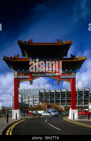 Chinatown-Bogen am Eingang zum Stowell Street, Chinatown, Newcastle Upon Tyne - mit St James' Park im Hintergrund Stockfoto