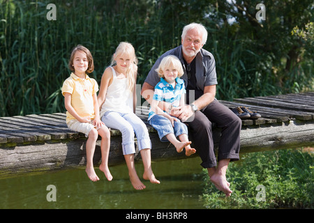 Großvater und Kinder am Steg Stockfoto