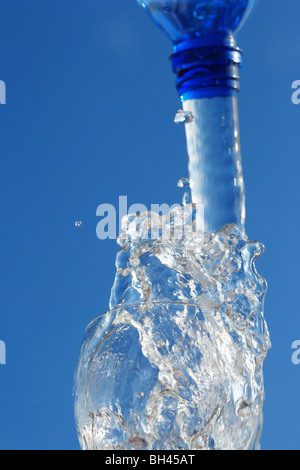 Spritzwasser aus der Flasche in ein Glas