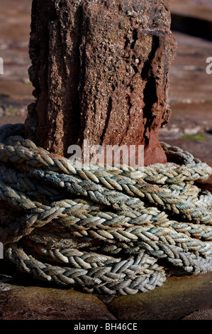 Seil gewickelt Runde alte steinerne Capstan im Hafen von Pennan. Stockfoto