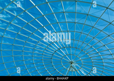 Strahlend blauer Himmel, durch eine moderne Architektur runden oder Spirale Fenster gesehen. Stockfoto