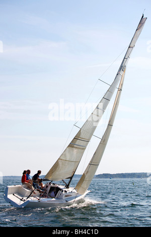 Drei Erwachsene genießen einen sonnigen Tag an Bord ein Daysailer auf Casco Bay, Maine. Stockfoto