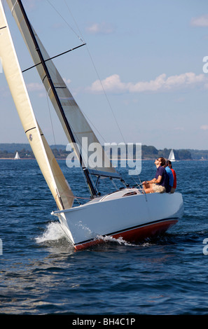 Drei Erwachsene genießen einen sonnigen Tag an Bord ein Daysailer auf Casco Bay, Maine. Stockfoto