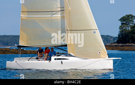 Drei Erwachsene genießen einen sonnigen Tag an Bord ein Daysailer auf Casco Bay, Maine. Stockfoto