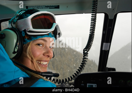 Ein Skifahrer Frau lächelt, als sie Co-Pilot beim Helikopter Skifahren in den Selkirk Mountains, Kanada spielt. Stockfoto