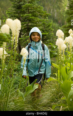 Ein junges Mädchen Wanderungen im Regen unter blühenden Bear Grass. Stockfoto