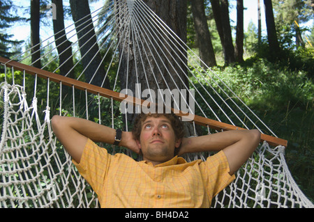 Ein junger Mann entspannt in einer Hängematte. Stockfoto