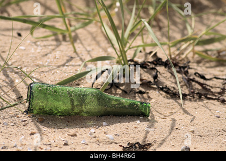 Leere Bierflasche verließ am Strand in der Nähe von Tain. Stockfoto