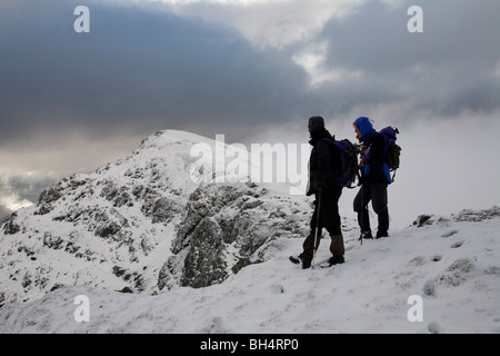 Zwei männliche Wanderer auf dem Gipfel des Stob Coire Creach, Loch Restil und Beinn Luibhean im Hintergrund. Arrochar Alpen Scotland UK Stockfoto