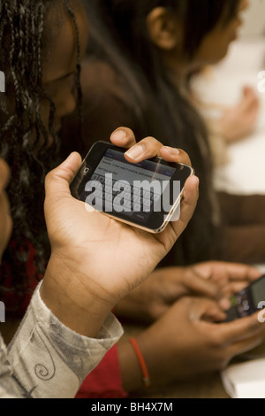 Schüler liest eine Nachricht auf ihrem Ipod Touch in der Mittelschule Technik Klasse wo Handys, Ipods und andere Geräte verwendet. Stockfoto