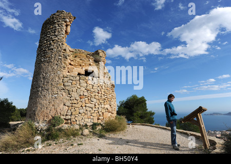 Frau liest Informationstafel & alte Windmühle auf La Plana, Javea / Xabia, Provinz Alicante, Comunidad Valenciana, Spanien Stockfoto