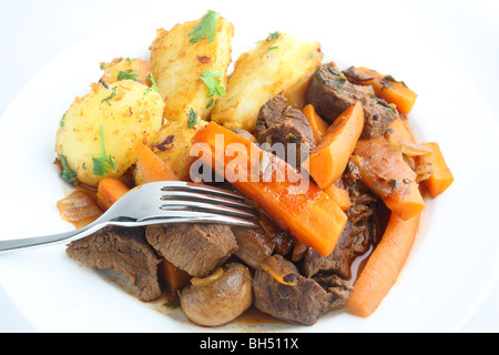 Französisches Rindfleisch und Karotten-Eintopf mit Kräutern, serviert mit Bratkartoffeln mit Petersilie garniert Stockfoto