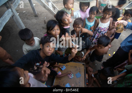 Einheimische Kinder spielen ein Brettspiel in einem Meer Zigeuner Dorf in Komodo Marine Park, Indonesien. Keine PR Stockfoto