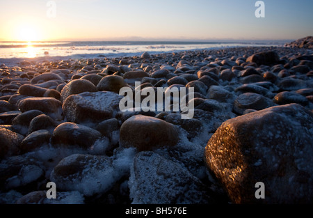 Vereisten Felsen am Meer bei Sonnenuntergang, Finnland Stockfoto