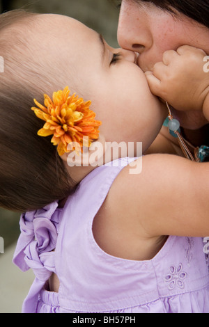 Ein kleines Mädchen küssen ihre Mutter Stockfoto