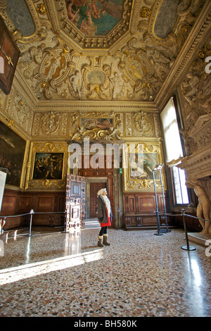 Ein einsamer Touristen steht in ein riesiges Zimmer mit verzierten Decke im Dogenpalast, Venedig, Italien. Stockfoto