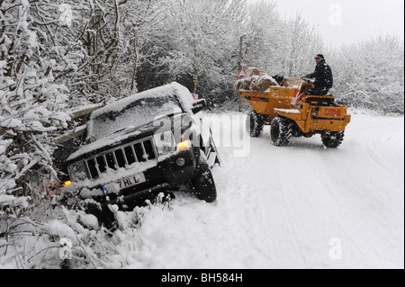 Ein Auto legt in einem Graben nach Kontrolle Kontrollverlust während der eisigen Fahrbedingungen. Stockfoto