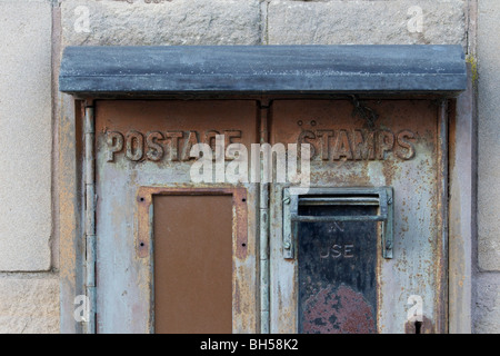 Stillgelegte alte Briefmarke-Automaten an der Wand einer schottischen Poststelle gesehen Stockfoto