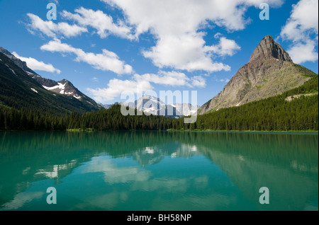 Mt. Grinnell wird im Hintergrund über dem blauem Wasser des Swiftcurrent Lake umrahmt. Stockfoto