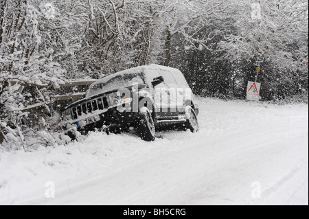 Ein Auto legt in einem Graben nach Kontrolle Kontrollverlust während der eisigen Fahrbedingungen. Stockfoto
