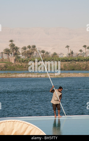 Mann, die Reinigung der Pool mit Blick auf den Nil im Hilton Luxor Resort &amp; Spa in Luxor, Ägypten, Afrika Stockfoto