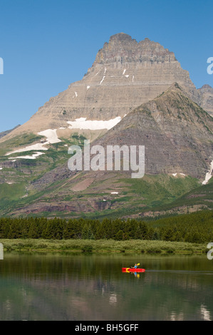 Mt. Wilbur steht hinter dem Swiftcurrent Lake wie eine rote Kanu im Many Glacier gleitet Stockfoto