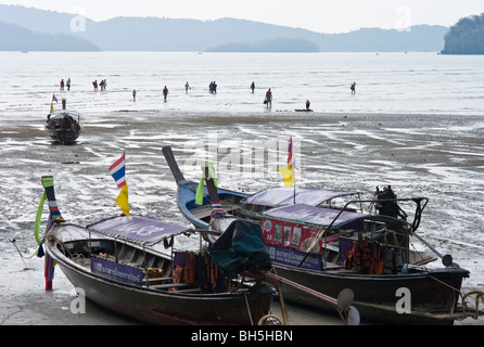 Leute aussteigen aus Boote bei Ebbe, Longtail-Boote, Noptharat Beach, Krabi Thailand Stockfoto