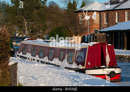 Schmale Boot mit Windgenerator vor Anker auf dem gefrorenen Llangollen Kanal bei Ellesmere, Shropshire Stockfoto