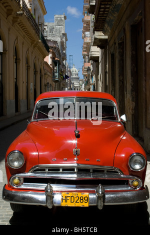 Rotes Auto - klassisches amerikanisches Ausweichen im Alten Havanna und das Kapitol der Stadt in der Ferne, Altes kubanischer Auto in Havanna Kuba, Reise in die Karibik Stockfoto