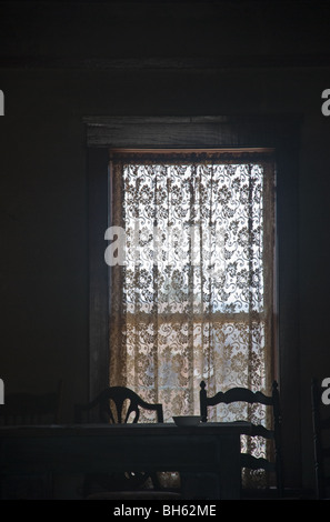 Spähen durch das Fenster ein lang-frei Haus in Carrizozo, scheint es, dass die Insassen nur abgereist sind. Stockfoto