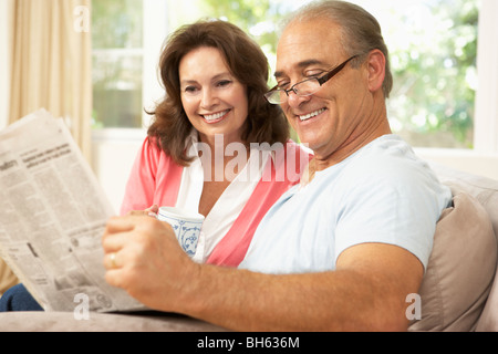 Älteres paar lesen Zeitung zu Hause Stockfoto