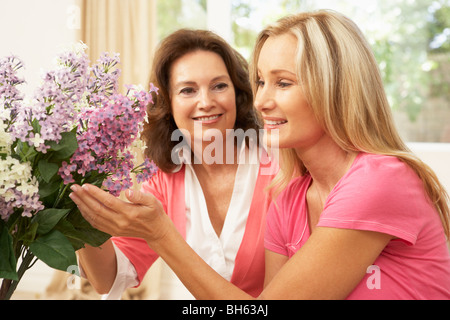 Ältere Frau und Tochter arrangieren zu Hause Blumen Stockfoto