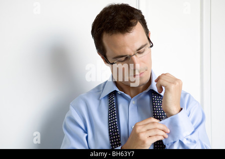 Ein Business-Mann tun oben seine Handfesseln Stockfoto