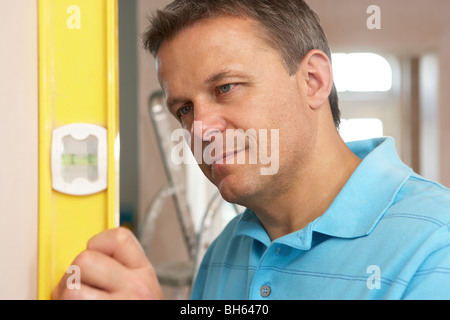 Generator mit Wasserwaage an Wand Stockfoto