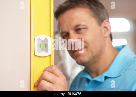 Generator mit Wasserwaage an Wand Stockfoto