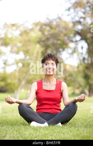 Ältere Frau beim Yoga im Park Stockfoto