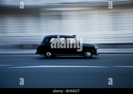 traditionellen schwarzen London Taxi Taxi fahren auf der Straße Bewegungsunschärfe Langzeitbelichtung Stockfoto