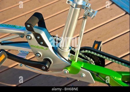 Mann, die Entfaltung einer Mobiky Klapprad auf einem Bootssteg mit Yachten Stockfoto